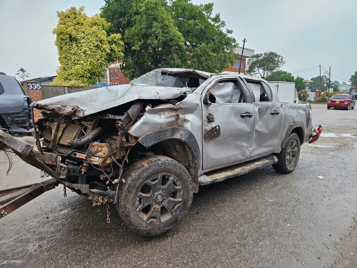 A silver Toyota Hilux before repair, front written off in an accident